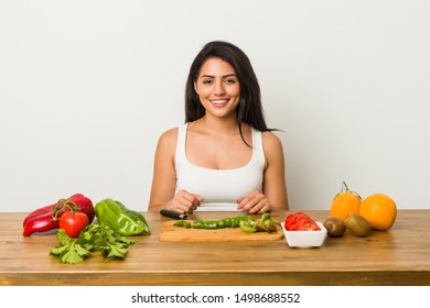 Young hispanic woman cutting vegetables on the table - Powered by Shutterstock