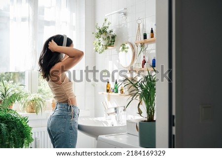Young hispanic woman dancing with headphones in bathroom. Body positivity, confort home zone, wellness and lifestyle Foto stock © 