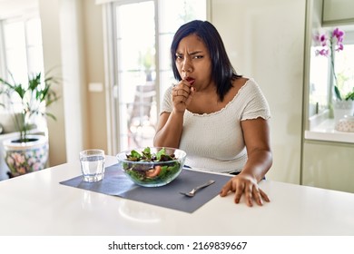 Young Hispanic Woman Eating Healthy Salad At Home Feeling Unwell And Coughing As Symptom For Cold Or Bronchitis. Health Care Concept. 