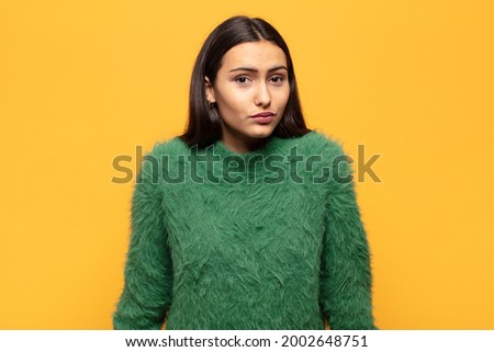 young hispanic woman feeling clueless and confused, having no idea, absolutely puzzled with a dumb or foolish look