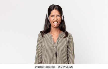 young hispanic woman feeling disgusted and irritated and tongue out with a headset. telemarketing concept