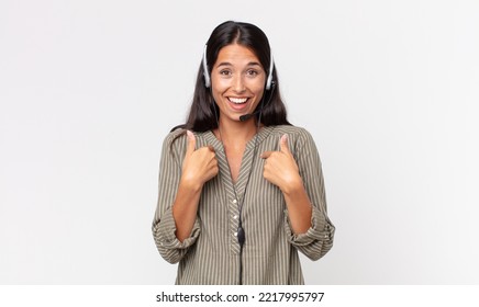 Young Hispanic Woman Feeling Happy And Pointing To Self With An Excited With A Headset. Telemarketing Concept