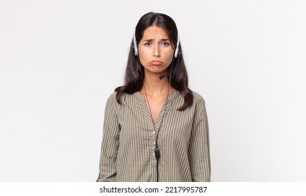 Young Hispanic Woman Feeling Sad And Whiney With An Unhappy Look And Crying With A Headset. Telemarketing Concept