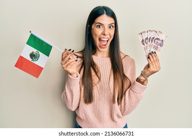 Young Hispanic Woman Holding Mexico Flag And Mexican Pesos Banknotes Celebrating Crazy And Amazed For Success With Open Eyes Screaming Excited. 