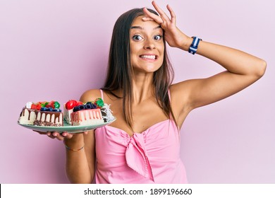 Young Hispanic Woman Holding Plate With Cheesecake Stressed And Frustrated With Hand On Head, Surprised And Angry Face 