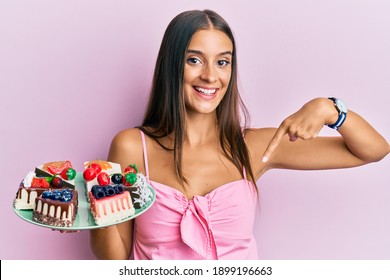 Young Hispanic Woman Holding Plate With Cheesecake Pointing Finger To One Self Smiling Happy And Proud 