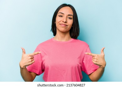 Young Hispanic Woman Isolated On Blue Background Person Pointing By Hand To A Shirt Copy Space, Proud And Confident