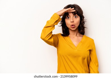 Young hispanic woman isolated on white background looking far away keeping hand on forehead.