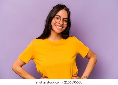 Young Hispanic Woman Isolated On Purple Background Confident Keeping Hands On Hips.