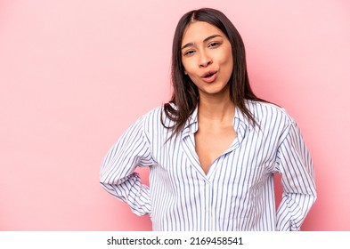 Young hispanic woman isolated on pink background being shocked because of something she has seen.