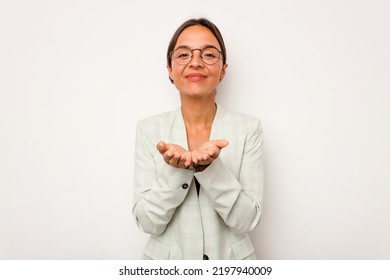 Young Hispanic Woman Isolated On White Background Holding Something With Palms, Offering To Camera.