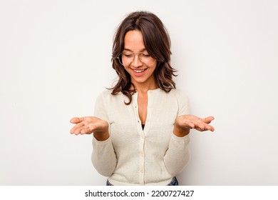 Young Hispanic Woman Isolated On White Background Holding Something With Palms, Offering To Camera.