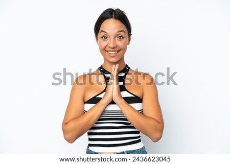 Young hispanic woman isolated on white background keeps palm together. Person asks for something