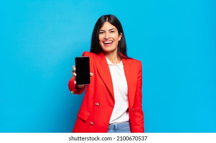 Young Hispanic Woman Looking Happy And Pleasantly Surprised, Excited With A Fascinated And Shocked Expression. Phone Screen Copy Space