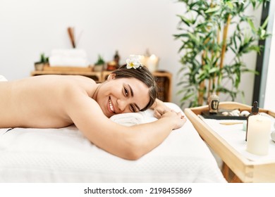 Young Hispanic Woman Lying On Massage Table At Beauty Center.