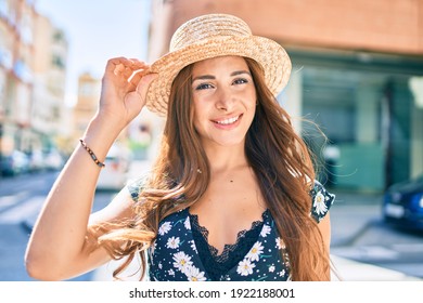 Young hispanic woman on vacation smiling happy walking at street of city.
