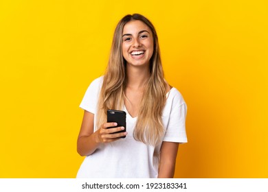 Young Hispanic Woman Over Isolated Yellow Background Using Mobile Phone