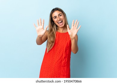 Young hispanic woman over isolated blue background counting ten with fingers