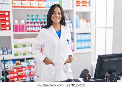Young hispanic woman pharmacist smiling confident standing at pharmacy - Shutterstock ID 2178199663
