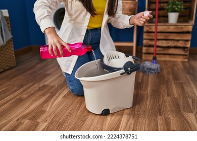 Young Hispanic Woman Pouring Clean Floor Product At Laundry Room