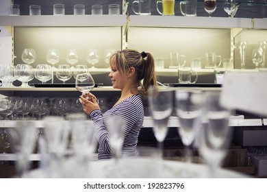 Young Hispanic Woman Shopping For Furniture, Glasses, Dishes And Home Decor In Store