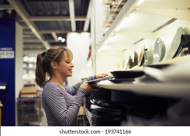 Young Hispanic Woman Shopping For Furniture, Glasses, Dishes And Home Decor In Store