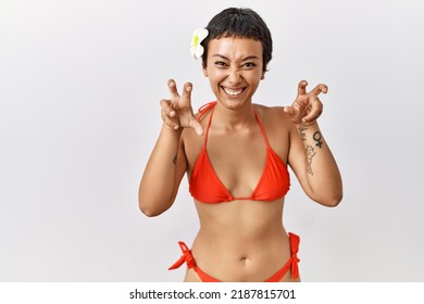 Young Hispanic Woman With Short Hair Wearing Bikini Smiling Funny Doing Claw Gesture As Cat, Aggressive And Sexy Expression 