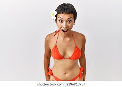 Young Hispanic Woman With Short Hair Wearing Bikini Afraid And Shocked With Surprise And Amazed Expression, Fear And Excited Face. 