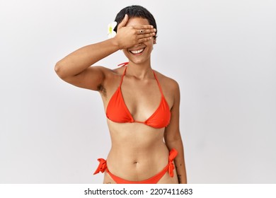 Young Hispanic Woman With Short Hair Wearing Bikini Smiling And Laughing With Hand On Face Covering Eyes For Surprise. Blind Concept. 