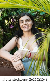 Una joven hispana sonríe y mira a una cámara afuera en un jardín en Yaguará, Huila, Colombia. Concepto de felicidad, belleza y pueblo colombiano