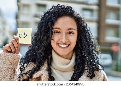 Young Hispanic Woman Smiling Confident Holding Smile Reminder At Street