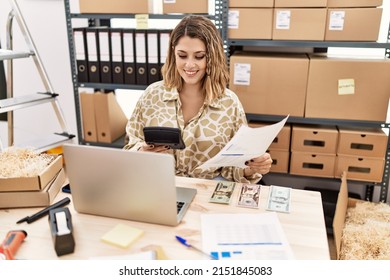 Young Hispanic Woman Smiling Confident Holding Calculator And Document At Office