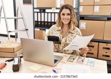 Young Hispanic Woman Smiling Confident Holding Calculator And Document At Office