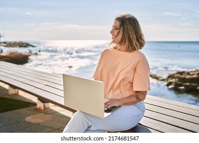 Young hispanic woman smiling confident using laptop at seaside