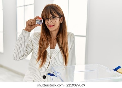 Young Hispanic Woman Smiling Confident Holding Vote Badge At Electoral College