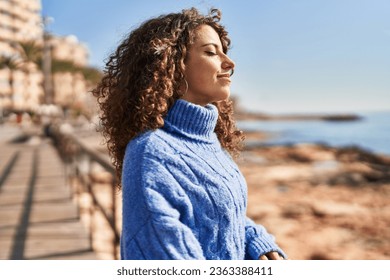 Young hispanic woman smiling confident breathing at seaside - Powered by Shutterstock