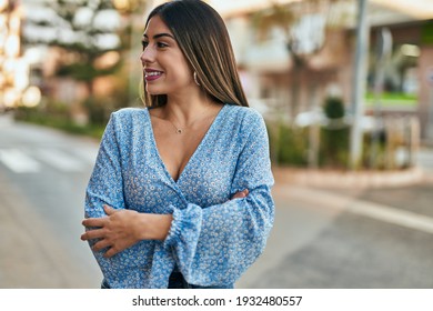 Young Hispanic Woman Smiling Happy With Arms Crossed At The City.