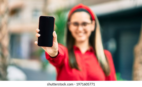 Young Hispanic Woman Smiling Happy Showing Screen Smartphone At The City.