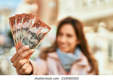 Young Hispanic Woman Smiling Happy Holding Australian Dollars At The City.