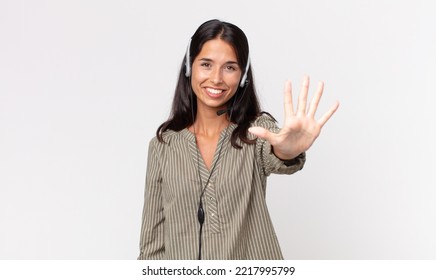 Young Hispanic Woman Smiling And Looking Friendly, Showing Number Five With A Headset. Telemarketing Concept