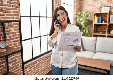 Young Hispanic Woman Speaking On The Phone About Bills Angry And Mad Screaming Frustrated And Furious, Shouting With Anger Looking Up. 