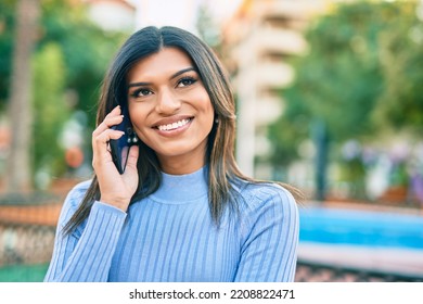 Young Hispanic Woman Speaking On The Phone At The Town