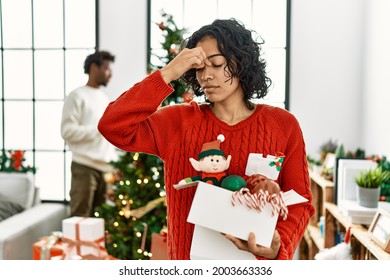 Young Hispanic Woman Standing By Christmas Tree With Decoration Tired Rubbing Nose And Eyes Feeling Fatigue And Headache. Stress And Frustration Concept. 