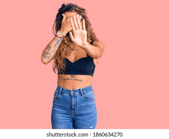 Young Hispanic Woman With Tattoo Wearing Casual Clothes And Glasses Covering Eyes With Hands And Doing Stop Gesture With Sad And Fear Expression. Embarrassed And Negative Concept. 