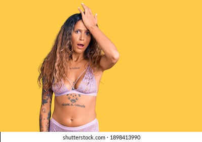 Young Hispanic Woman With Tattoo Wearing Lingerie Surprised With Hand On Head For Mistake, Remember Error. Forgot, Bad Memory Concept. 