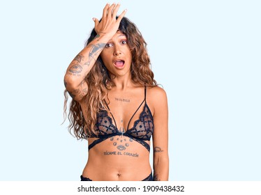 Young Hispanic Woman With Tattoo Wearing Lingerie Surprised With Hand On Head For Mistake, Remember Error. Forgot, Bad Memory Concept. 