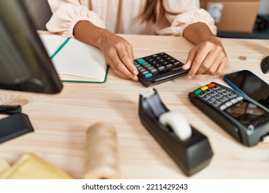 Young Hispanic Woman Using Calculator At Storehouse