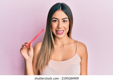 Young Hispanic Woman Using File Nail Looking Positive And Happy Standing And Smiling With A Confident Smile Showing Teeth 