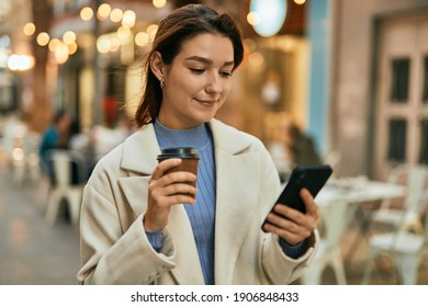 Young Hispanic Woman Using Smartphone And Drinking Coffee At The City.