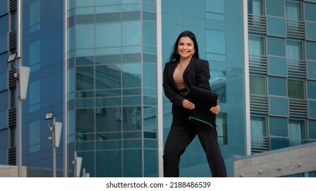 Young hispanic woman walking down street carrying briefcase looks around happy student girl jumps incendiary dancing passed exam funny businesswoman rejoices received dream job career advancement - Shutterstock ID 2188486539